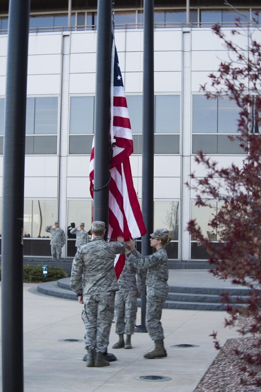 Airmen with the 50th Space Wing raise the flag during reveille at Schriever Air Force Base, Colorado, Thursday, May 5, 2016. As part of its tradition, Team 5-0 holds either reveille or retreat every month to honor the Stars and Stripes. (U.S Air Force photo/Tech. Sgt. Julius Delos Reyes)