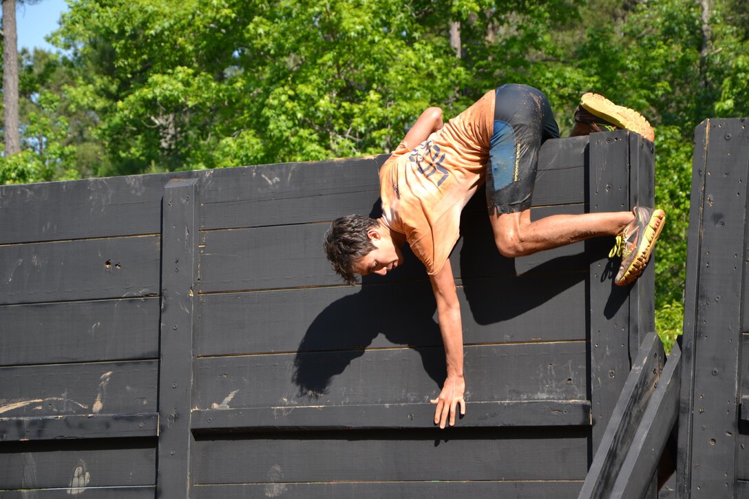 Chad Turnig, of Ashland, Ky., climbs over the "Berlin Wall" obstacle at the 2016 Atlanta Tough Mudder. Partnered with the Army Marketing Research Group, the muddy event was held May 7 and 8, 2016, at Bouckaert Farms in Fairburn, Ga.