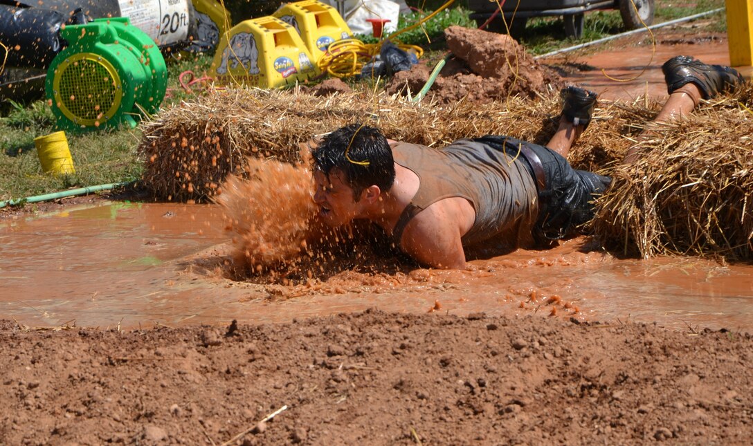 2016 Atlanta Tough Mudder participant Stephen Schroeder mud-crawls to the finish line May 8, 2016. Partnered with the Army Marketing Research Group, the muddy obstacle course event was held May 7 and 8, 2016, at Bouckaert Farms in Fairburn, Ga.