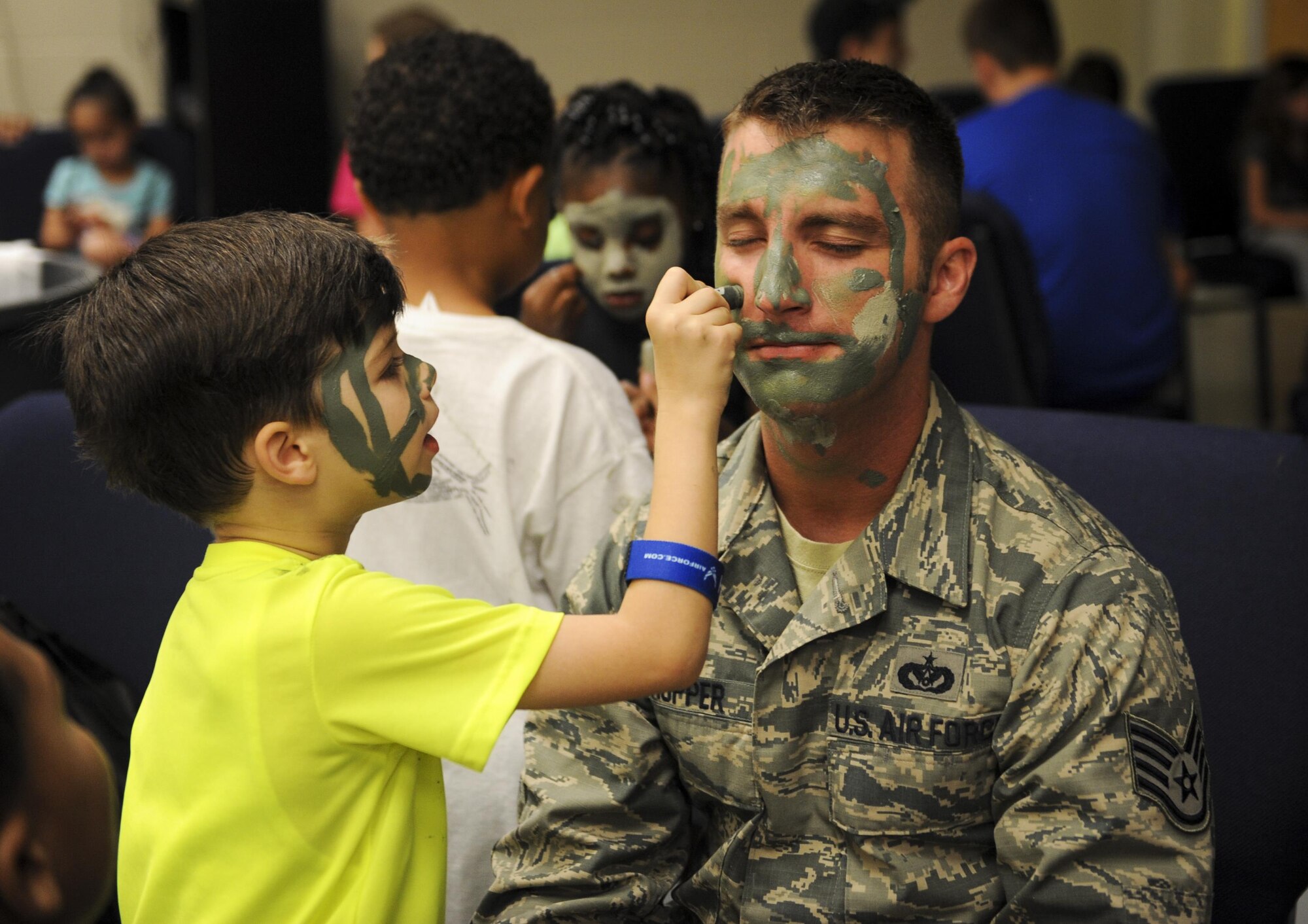 A military child paints the face of Staff Sgt. Kody Hopper, a professional military education instructor with the 1st Special Operations Force Support Squadron, during Operation Kids Understanding Deployment Operations at Hurlburt Field, Fla., April 30, 2016. Operation KUDOS is an educational event aimed to help build resiliency in military youth by engaging them in activities that simulate the pre-deployment experience, such as pre-deployment lines and demonstrations and games held by multiple squadrons around Hurlburt. The event concluded with a “homecoming” where parents welcomed back their children. (U.S. Air Force photo by Senior Airman Meagan Schutter)