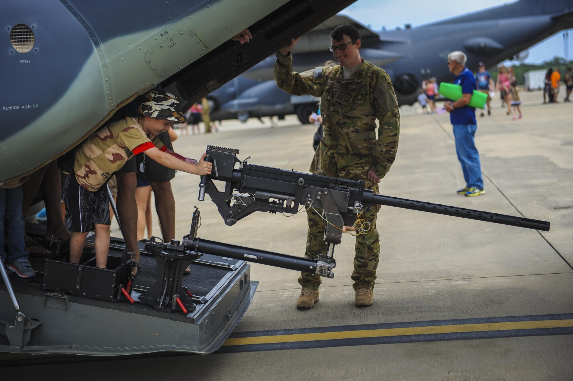A child pretends to fire a 50-caliber machine gun on a CV-22 Osprey during Operation Kids Understanding Deployment Operations at Hurlburt Field, Fla., April 30, 2016. The School Liaison Program hosted KUDOS to educate kids on the deployment process, engaging them in activities that help show children similar situations their parents go through during pre-deployment. After a “homecoming” families were able to explore aircraft on the flightline. (U.S. Air Force photo by Senior Airman Meagan Schutter)