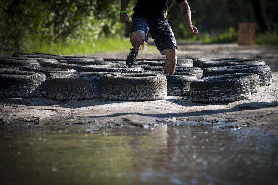 A contestant runs through tires during the 2016 Moody Mudder, May 7, 2016, in Ray City, Ga. During the race, the runners faced obstacles such as tires, monkey bars, a fire pit, and a low-crawl under barbwire. (U.S. Air Force photo by Airman 1st Class Lauren M. Hunter/Released)

