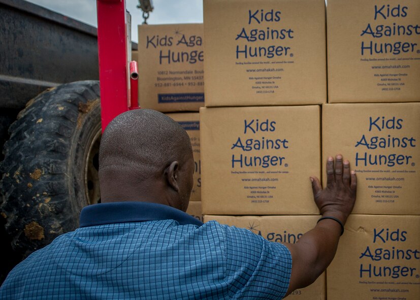 A charity worker on the ground in Grand Goave, Haiti accepts Denton Program humanitarian cargo after members of the 701st Airlift Squadron delivered about 700,000 pounds of cargo to the island nation April 21.  (U.S. Air Force photo by Senior Airman Tom Brading)