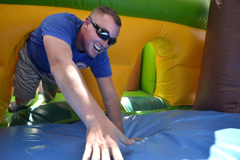 Staff Sgt. Nathon Wheat, 379th Space Range Squadron, crawls through a tunnel during the annual Sexual Assault Awareness and Prevention Month inflatable run at the Schriever Air Force Base, Colorado, running path Thursday, May 5, 2016. The base-wide run was hosted by the Sexual Assault Prevention and Response office to raise awareness about sexual assault. (U.S. Air Force Photo/Dennis Rogers)