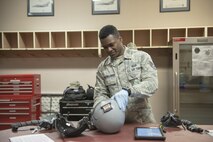 U.S. Air Force Staff Sgt. Jonathan McCullough, an 8th Operations Support Squadron aircrew flight equipment (AFE) journeyman assigned to Kunsan Air Base, Republic of Korea, inspects a flight helmet, May 2, 2016, at Eielson Air Force Base, Alaska. AFE technicians perform inspections of pilots' equipment daily to ensure it functions properly. (U.S. Air Force photo by Staff Sgt. Ashley Nicole Taylor/Released)