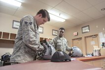 U.S. Air Force Staff Sgt. Jonathan McCullough and Senior Airman Daniel Godfrey, 8th Operations Support Squadron aircrew flight equipment (AFE) journeymen assigned to Kunsan Air Base, Republic of Korea, inspect flight equipment, May 2, 2016, at Eielson Air Force Base, Alaska. AFE technicians check each piece of equipment a pilot needs and makes sure it is in proper working condition before each sortie. (U.S. Air Force photo by Staff Sgt. Ashley Nicole Taylor/Released)