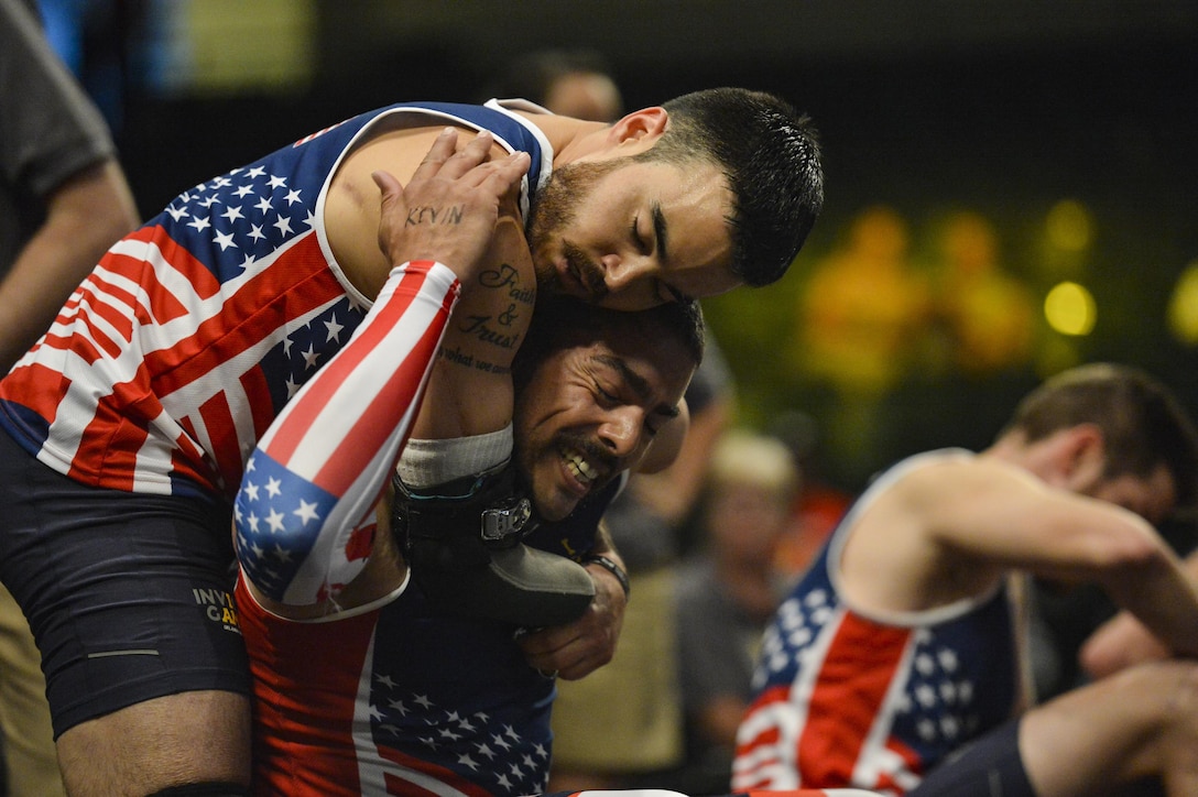 Retired Air Force Staff Sgt. Daniel Crane, left, and retired Army Staff Sgt. Michael Kacer embrace one another after competing in a rowing event during the 2016 Invictus Games in Orlando, Fla., May 9, 2016. Air Force photo by Tech. Sgt. Joshua L. DeMotts