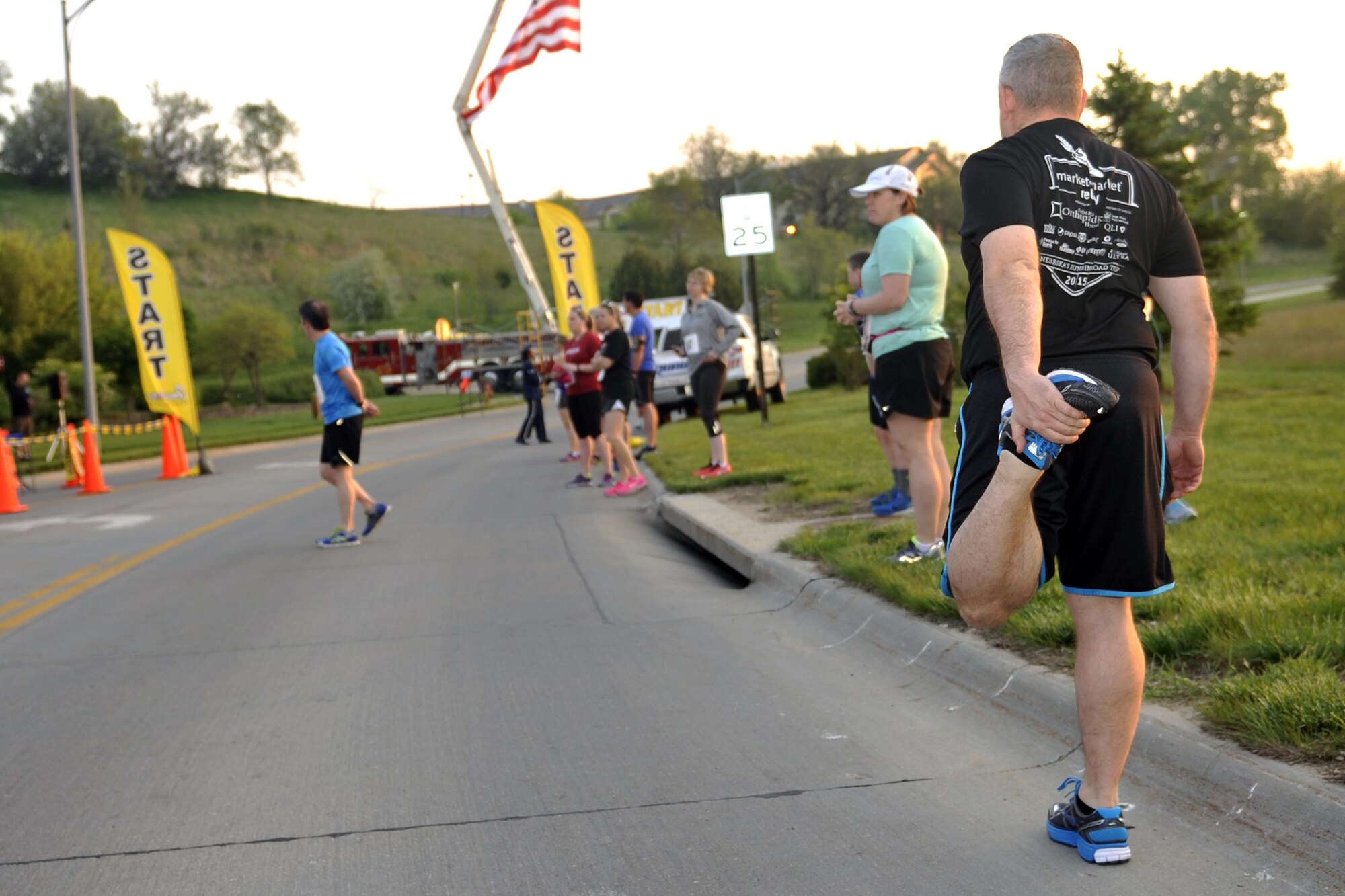 Participants stretch as they prepare for the eighth annual Bellevue-Offutt Runway Run at Offutt Air Force Base, Neb., May 8, 2016. More than 100 runners participated in this unique seven-mile race that takes runners past parked aircraft and down the Offutt runway. (U.S. Air Force photo by Jeff Gates)
