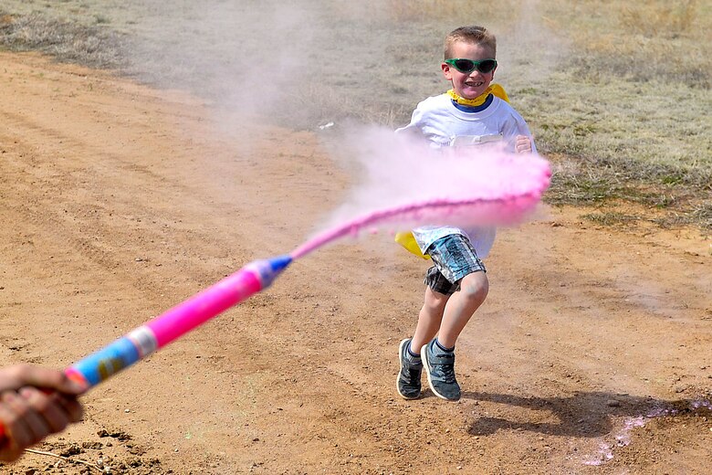 A volunteer sprays Ethan Buckholdt with colored powder during the annual America’s Armed Forces Kids Run at Schriever Air Force Base, Colorado, Friday, May 6, 2016. Buckholdt was one of the more than 30 runners who participated in the event honoring Month of the Military Child and Child Abuse Prevention Month. (U.S. Air Force photo/Katie Calvert)