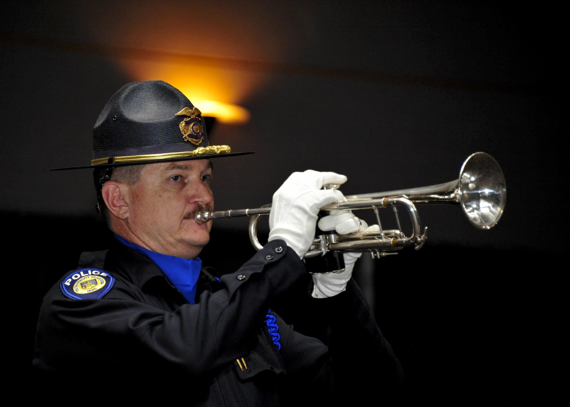 Detective John Dorer, University of Arizona Police Department officer, plays taps with a trumpet during the 9th Annual Pima County Regional Law Enforcement Memorial at the Tucson Convention Center in Tucson, Ariz., May 6, 2016.  The memorial was held to honor local members of law enforcement who have lost their lives while serving in the line of duty.  (U.S. Air Force photo by Senior Airman Chris Massey/Released)