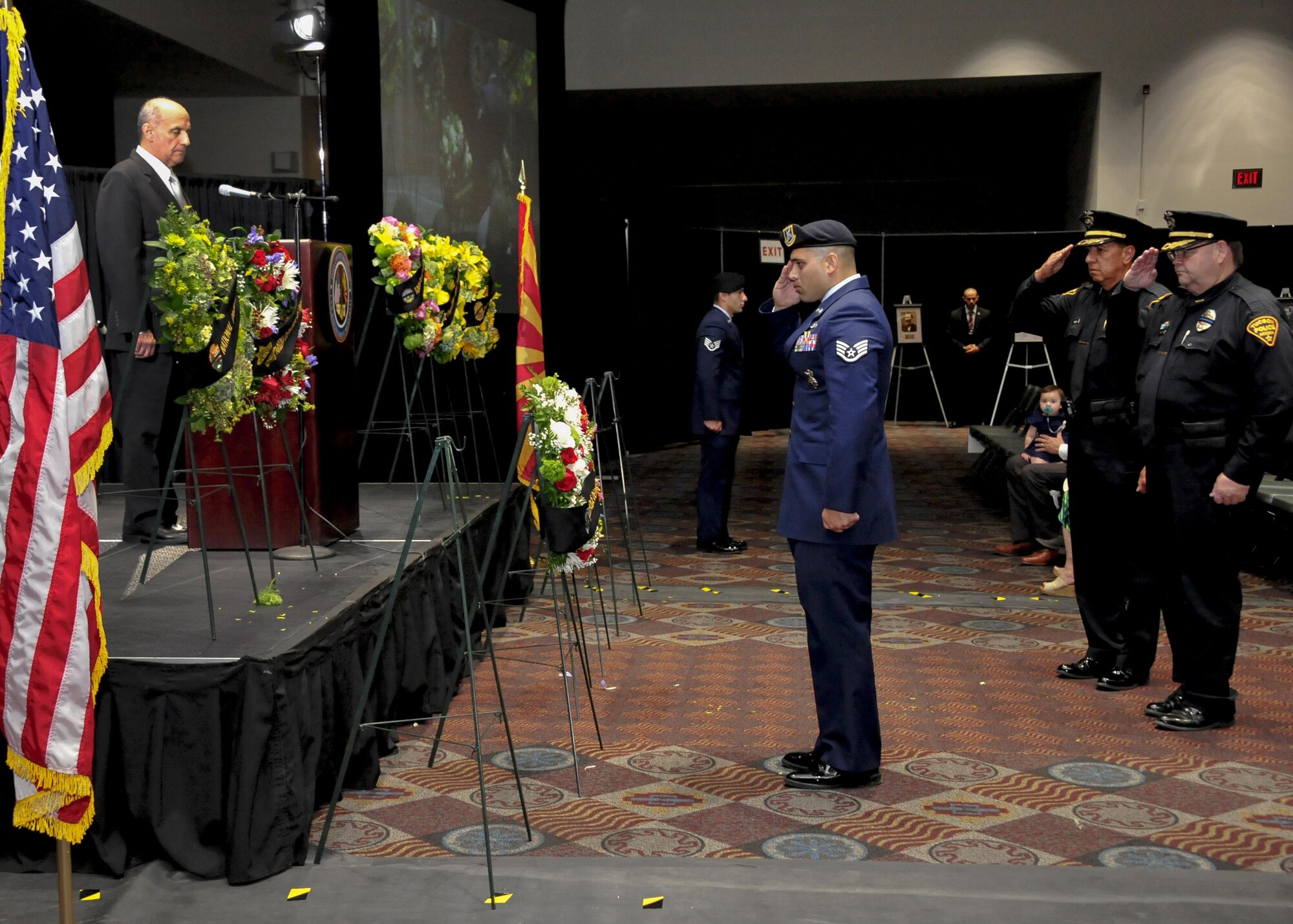 U.S. Air Force Staff Sgt. Michael Doria, 355th Security Forces Squadron member, salutes a wreath with Tucson Police Department officers during the 9th Annual Pima County Regional Law Enforcement Memorial at the Tucson Convention Center in Tucson, Ariz., May 6, 2016.  A wreath was presented by 11 local law enforcement agencies to honor past members who have perished while in the line of duty.  (U.S. Air Force photo by Senior Airman Chris Massey/Released)