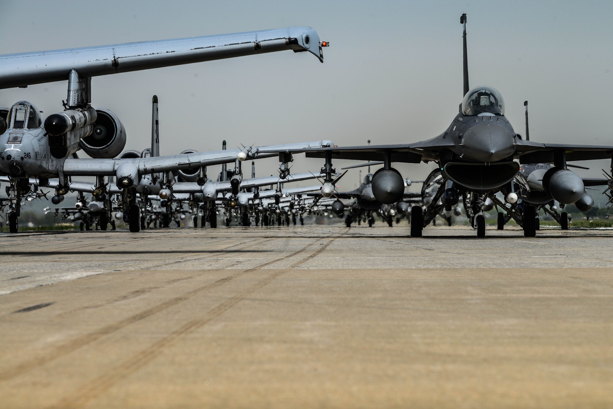 A-10 Thunderbolt II and F-16 Fighting Falcon fighter aircraft perform an 'Elephant Walk' on the runway this week during Exercise Beverly Herd 16-01 at Osan Air Base, Republic of Korea. The Elephant Walk was a demonstration of U.S. Air Force capabilities and strength and showcases the wing's ability to generate combat airpower in an expedient manner in order to respond to simulated contingency operations. The A-10 Thunderbolt II aircraft are the 25th Fighter Squadron "Draggins" and the F-16 Fighting Falcon aircraft are the 36th Fighter Squadron "Friends" from the 51st Fighter Wing, Osan AB, ROK; the additional F-16 aircraft are the 179th Fighter Squadron "Bulldogs" from the 148th Fighter Wing out of Duluth Air National Guard Base, Minnesota. (U.S. Air Force photo by Senior Airman Dillian Bamman/Released)