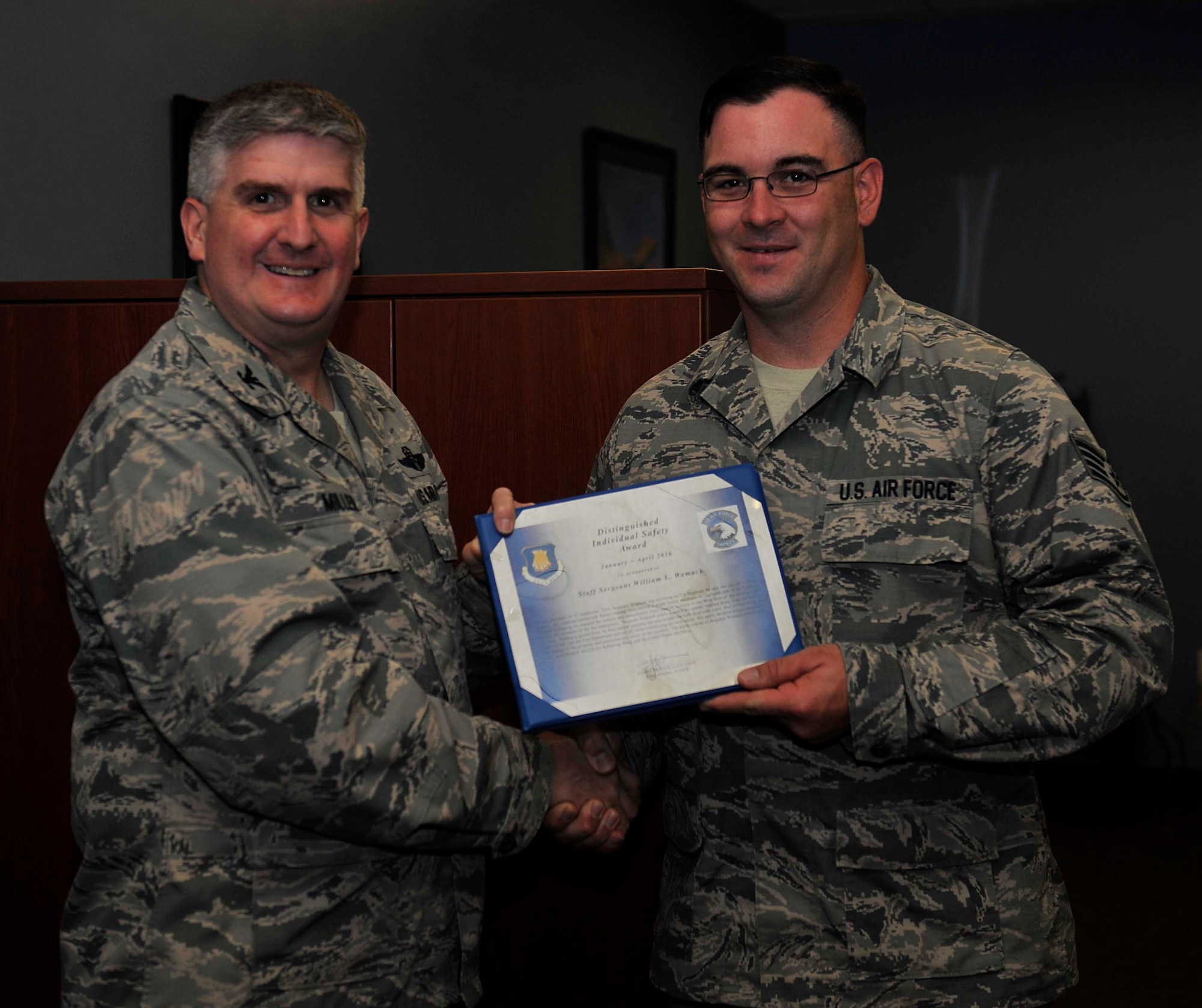 Staff Sgt. William Womack, right, 22nd Aircraft Maintenance Squadron crew chief, accepts the Distinguished Individual Safety Award from Col. Albert Miller, 22nd Air Refueling Wing commander, May 6, 2016, at McConnell Air Force Base, Kan. Womack received the award for pulling a homeowner from a burning house before extinguishing the fire, Sept. 15, 2014. (U.S. Air Force photo/Airman Erin McClellan)