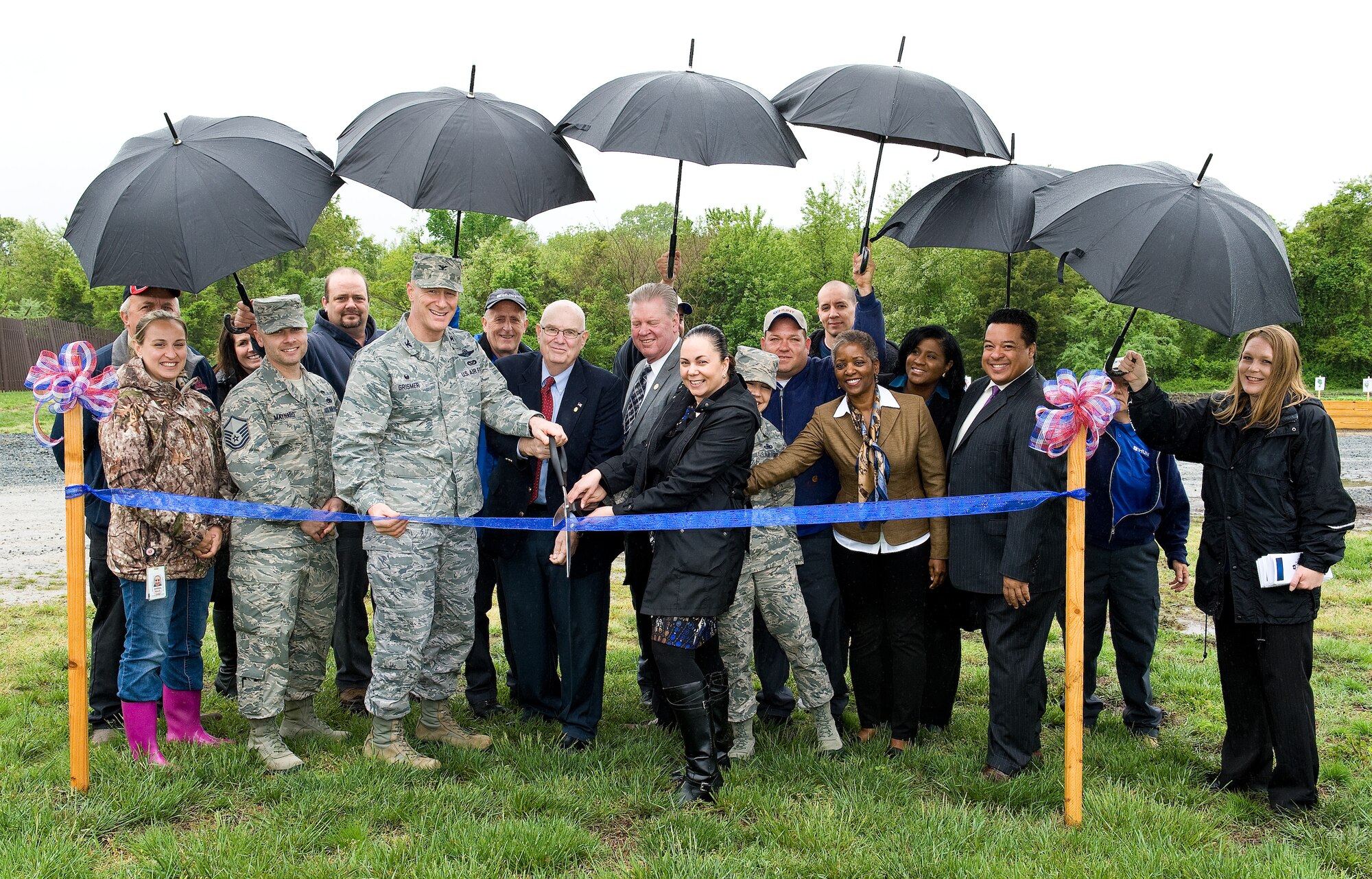 In the center, left to right, holding the ceremonial scissors, Col. Michael Grismer, 436th Airlift Wing commander; Bill Hare, Dover Air Force Base honorary commander alumni chairman; James Waddington, Kent County Levy Court, Dover, Delaware, Kent Economic Partnership director; and Sophia Reeves, Hunt Companies, Inc., Military Housing Communities, Dover AFB community director; and Chief Master Sgt. Sarah Sparks, 436th AW command chief; get ready to cut the ribbon May 6, 2016, at the organic community garden on Dover AFB, Del. The garden will be 60-feet-wide by 120-feet-long with no individual plots allowed, strictly organic, no chemical pesticides or fertilizers will be used. (U.S. Air Force photo/Roland Balik)