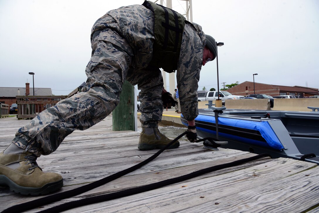 U.S. Air Force Staff Sgt. Shawn McNamara, a base defense operation center controller with the 633rd Security Forces Squadron, learns how to correctly tie a boat to a dock at Langley Air Force Base, Va., May 5, 2016. The boat patrol will secure nine miles of shoreline to help protect the base. (U.S. Air Force photo by Senior Airman Kristina LaCoste)
