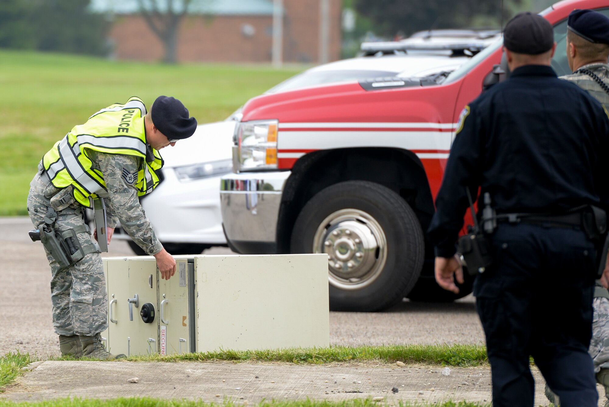 An 88th Security Forces Squadron member checks on a classified safe that had been dumped in a field by a simulated tornado during a base exercise at Wright-Patterson Air Force Base, May 5. Security Forces members must secure these safes until the proper organization can arrive to claim it. (U.S. Air Force photo/Wesley Farnsworth)