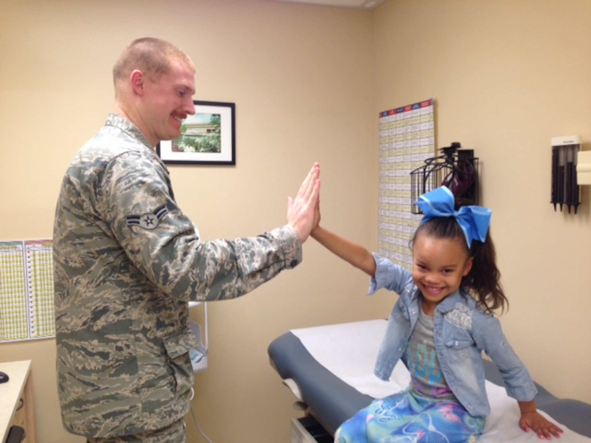 Airman 1st Class Cody Sellick, a pediatric medical technician at the Wright-Patterson Air Force Base Medical Center, screens a patient for a sports physical. (Courtesy photo)