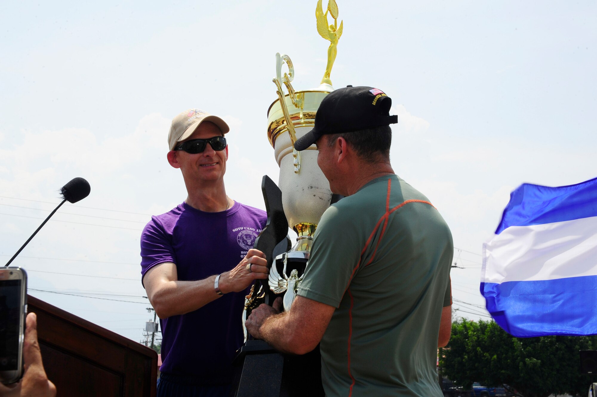 U.S. Air Force Lt. Col. Jim Trachier, Joint Task Force-Bravo deputy commander/chief of staff, hands the Camaraderie Day trophy to Honduran Army Brig. Gen. Rene Ponce Fonseca, the Honduran Army Forces commander, during the 2016 Camaraderie Day closing ceremony at Soto Cano Air Base, Honduras, May 5, 2016. Camaraderie Day is a special event that celebrates the relationship between Honduras and the U.S. through athletic events. (U.S. Army photo by Martin Chahin/Released)