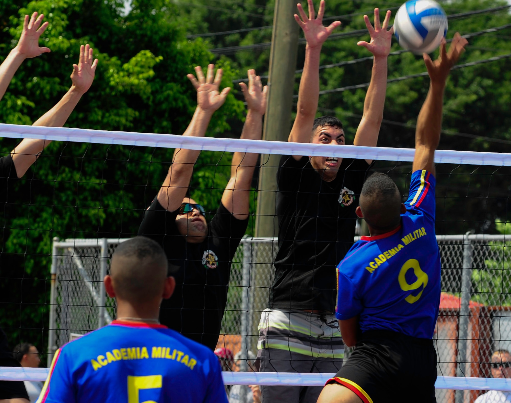 Members of the Joint Task Force-Bravo volleyball team attempt to block a spike from a member of the Honduran Military Training Academy team during the 2016 Camaraderie Day at Soto Cano Air Base, Honduras, May 5, 2016. The day began with a morning formation of the U.S. and Honduran participants, which included the playing of the national anthems of both countries. (U.S. Army photo by Martin Chahin/Released)