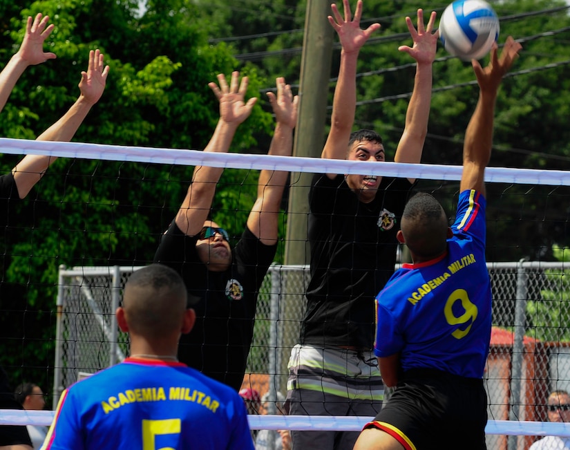 Members of the Joint Task Force-Bravo volleyball team attempt to block a spike from a member of the Honduran Military Training Academy team during the 2016 Camaraderie Day at Soto Cano Air Base, Honduras, May 5, 2016. The day began with a morning formation of the U.S. and Honduran participants, which included the playing of the national anthems of both countries. (U.S. Army photo by Martin Chahin/Released)