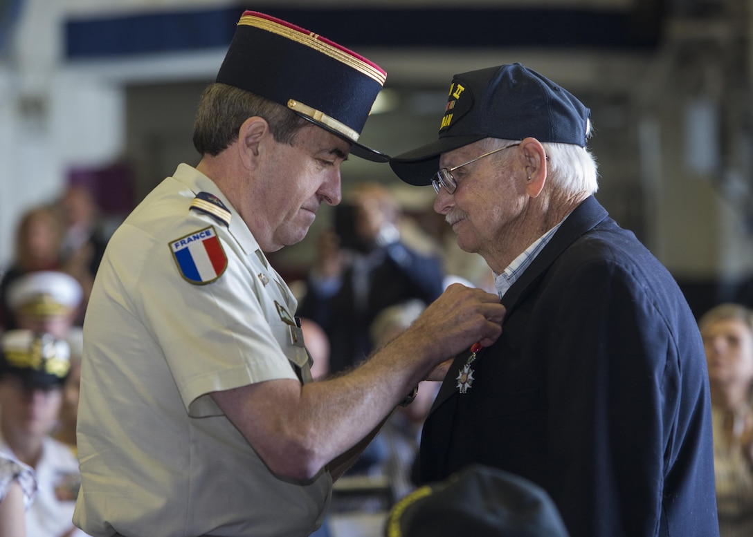 Capt. Jean-Michel Caffin of the French Army Reserve pins the Legion of Honor Medal onto an American World War II veteran aboard the USS Bataan during the Legion of Honor Ceremony in Fort Lauderdale, Fla., May 7, 2016. During the ceremony the Consulate General of France, Philippe Létrilliart, awarded nine American veterans with the Legion of Honor Medal for their heroic actions during the invasion of Normandy. The purpose of the event was to remember how important it is to pay tribute to the veterans who served so valiantly and also to highlight the long-standing friendship between the United States and France. (U.S. Marine Corps photo by Cpl. Michelle Reif/Released.)