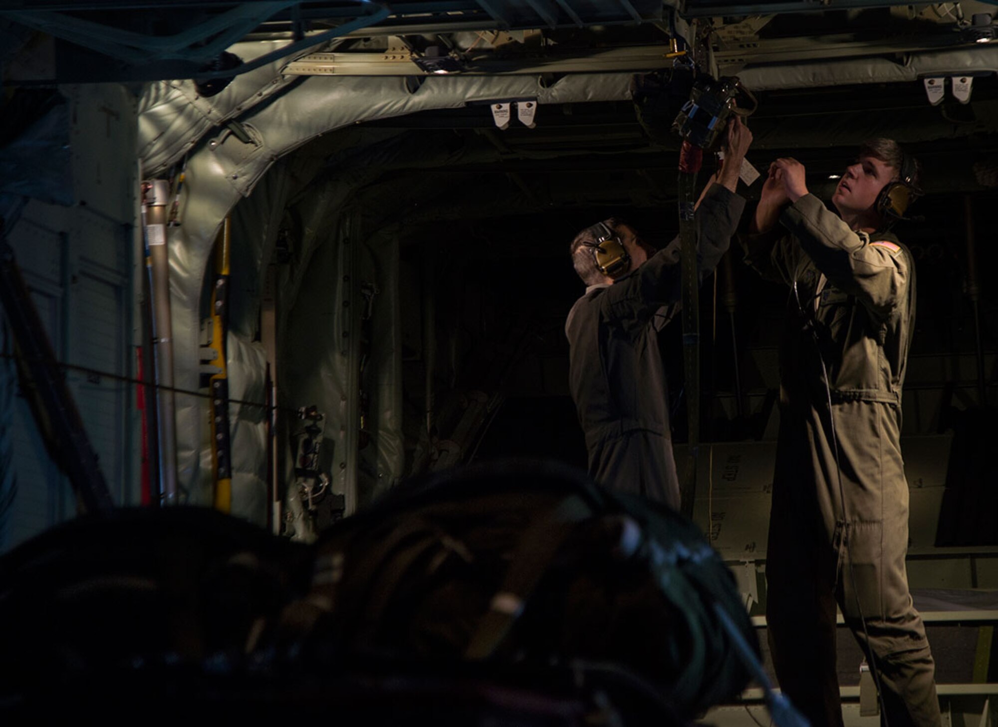 U.S. Air Force Tech Sgt. Nick Camino, left, and Staff Sgt. Thomas Parris, loadmasters both assigned to the 17th Operations Squadron, conduct an in-flight rigging of a heavy equipment extraction parachute during Red Flag Alaska 16-1, May 5, 2016. RFA is a series of Pacific Air Forces commander-directed training exercises for U.S. and international forces to provide joint offensive, counter-air, interdiction, close air support, and large force employment in a simulated combat environment. ((U.S. Air Force photo by Staff Sgt. Sheila deVera)
