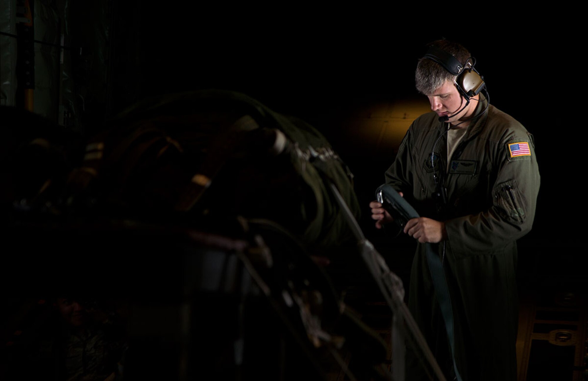 U.S. Air Force Staff Sgt. Thomas Parris, 17th Operations Squadron loadmaster, rolls a harness in preparation for an airdrop during Red Flag Alaska 16-1, May 5, 2016. (U.S. Air Force photo by Staff Sgt. Sheila deVera)