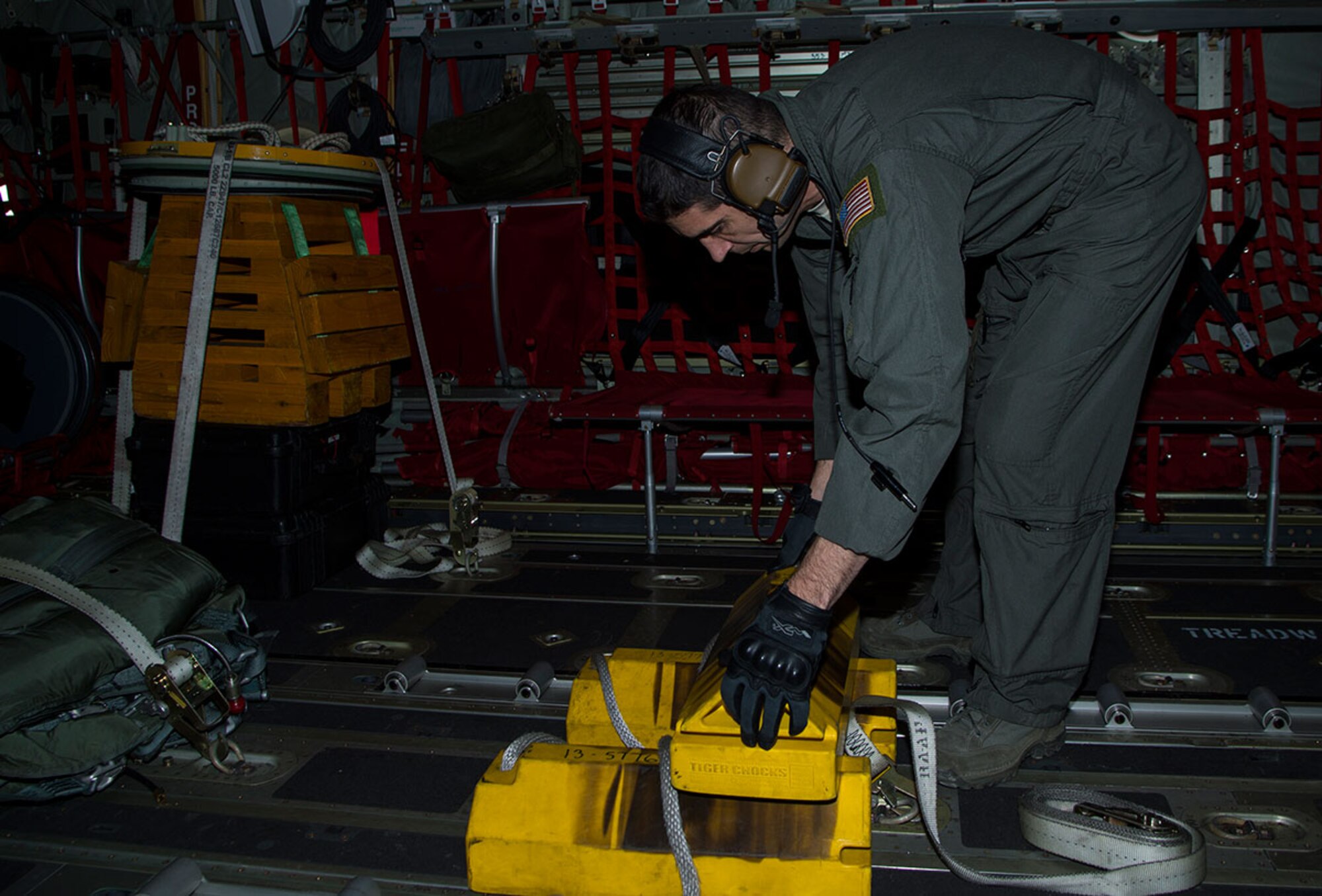Tech. Sgt. Nick Camino, 17th Special Operations Squadron loadmaster, secures a chock block before take-off during Red Flag-Alaska 16-1 at Joint Base Elmendorf-Richardson, Alaska, May 5, 2016. RFA provides joint offensive counter-air, interdiction, close air support, and large force employment training in a simulated combat environment. (U.S. Air Force photo by Staff Sgt. Sheila deVera)
