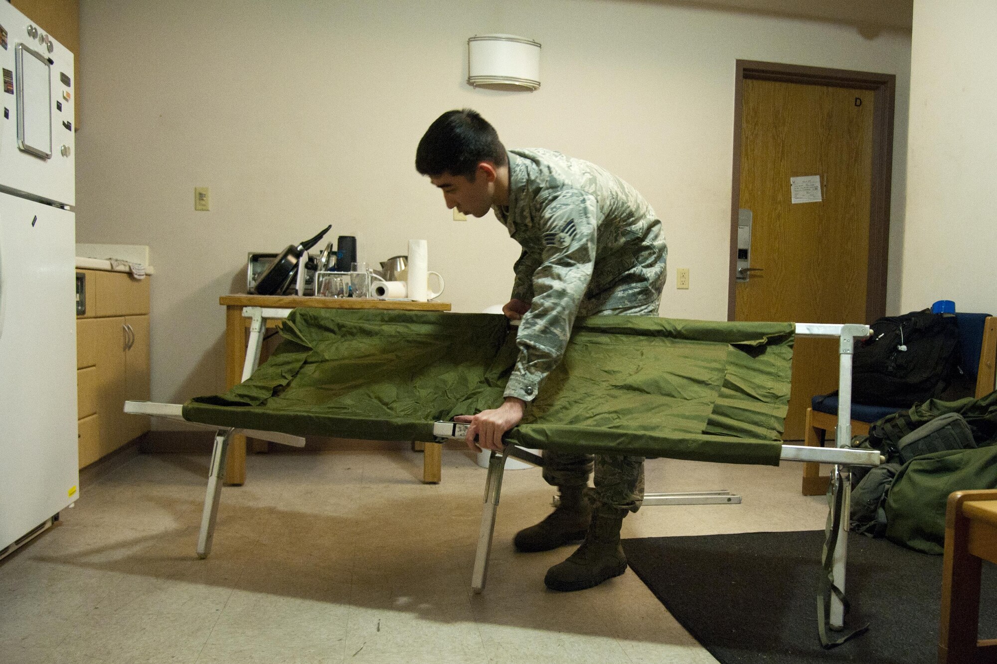 Senior Airman Maximillian Wyckoff, 51st Munitions Squadron precision guidance crew chief, sets up a cot to sleep in a collective protection system facility May 9, 2016, at Osan Air Base, Republic of Korea. The CPS facilities provide a chemical and biological-free environment to sleep and exercise in. (U.S.  Air Force photo by Staff Sgt. Jonathan Steffen/Released)