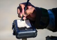 A 51st Civil Engineer Squadron Airman marks a piece of M8 Chemical Detection Paper during a training exercise at Osan Air Base, Republic of Korea, May 11, 2016. The Airmen used the M8 paper to detect the presence of liquid, nerve and blister chemical agents after a simulated attack on the base, and is marked to ensure each piece can be properly documented for identification purposes. (U.S. Air Force photo by Senior Airman Victor J. Caputo/Released)