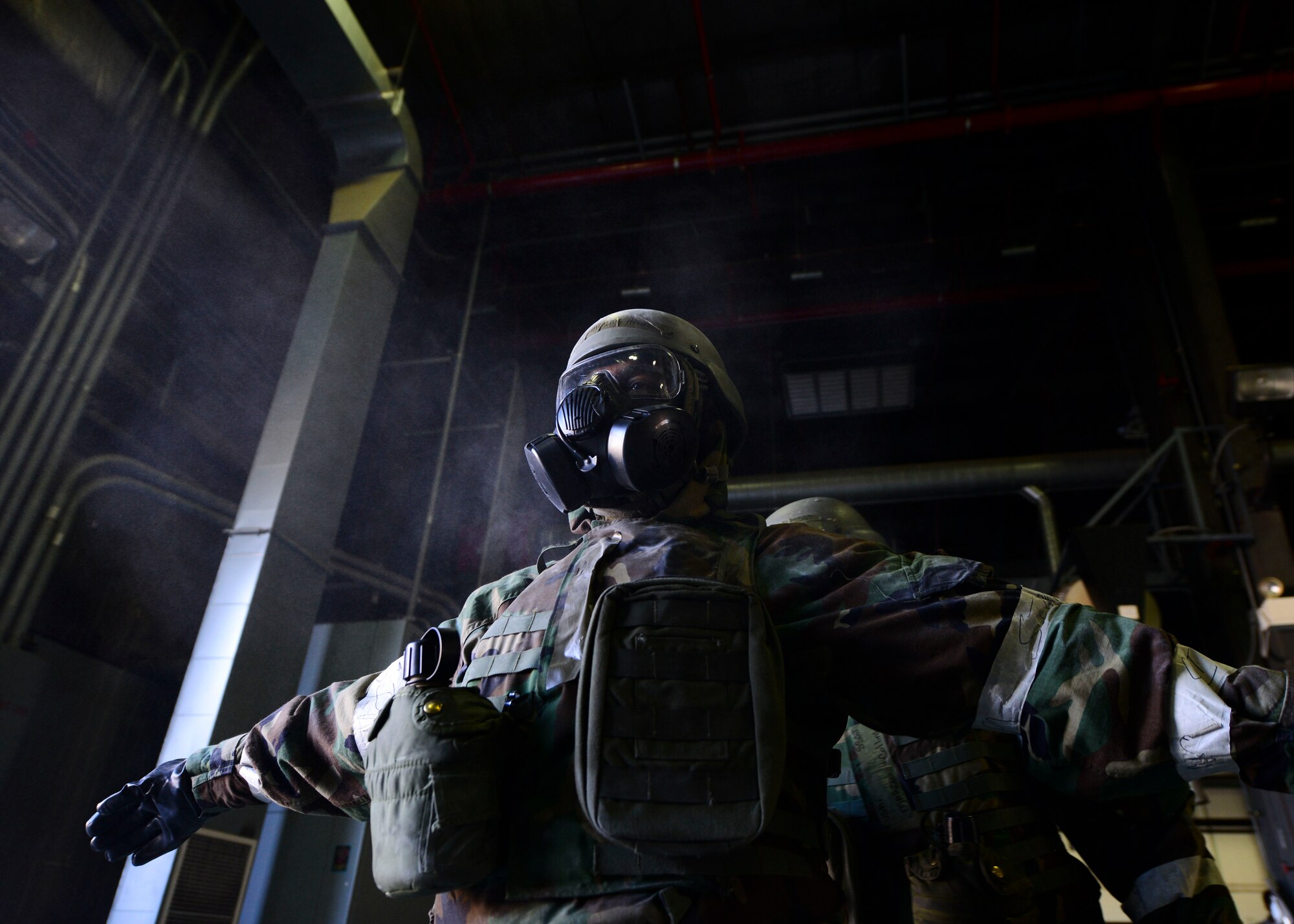 Staff Sgt. Henderson Anthony, 51st Civil Engineer Squadron structural craftsman, stands in a cloud of decontamination powder as his Mission Oriented Protective Gear is decontaminated by his wingman at Osan Air Base, Republic of Korea, May 11, 2016. Dozens of 51st CES Airmen participated in a training scenario covering wartime survivability skills during Exercise Beverly Herd 16-01. (U.S. Air Force photo by Senior Airman Victor J. Caputo)