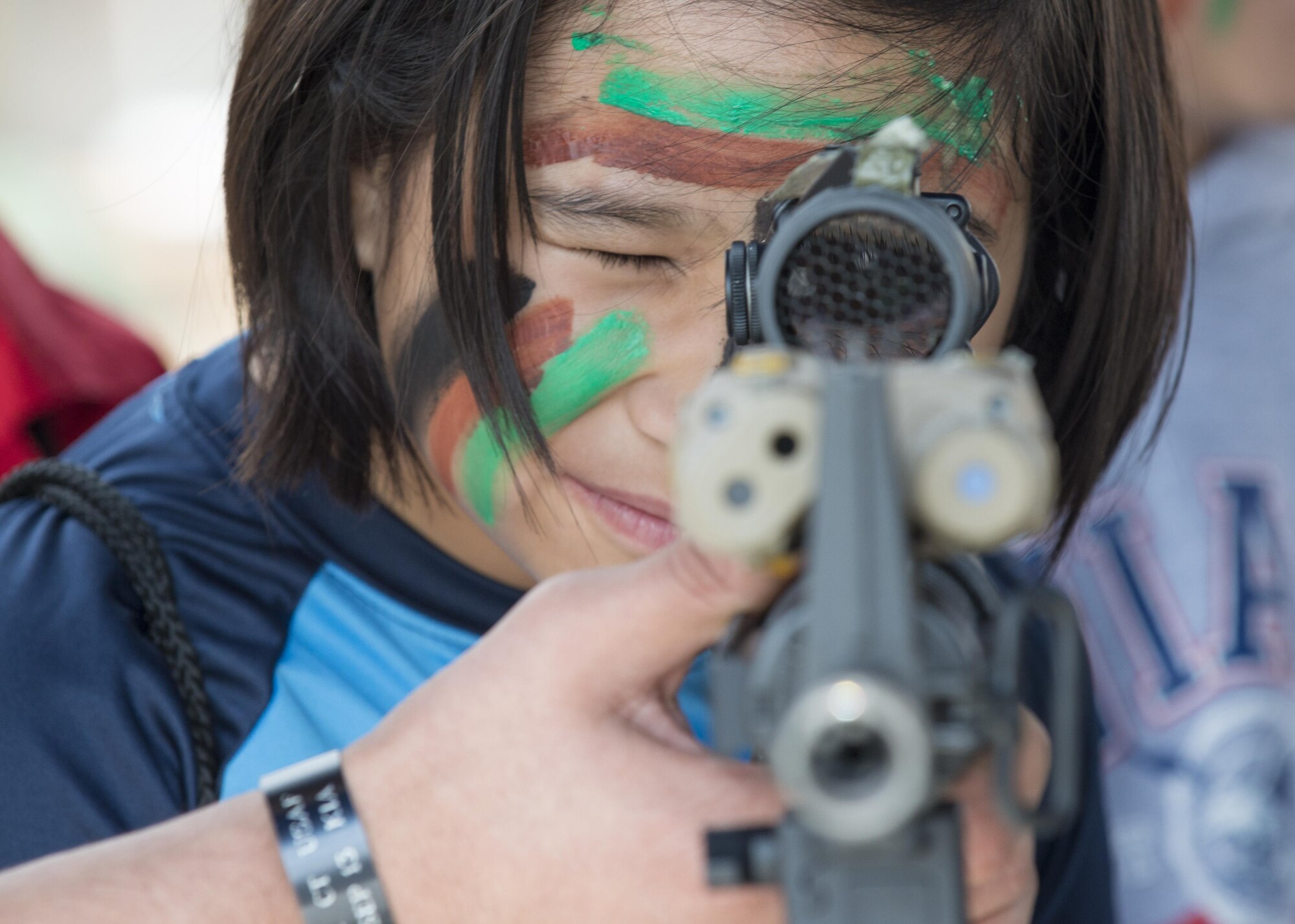 Allana Cruz, Aviano Elementary School student, looks through a rifle scope during a Little Wyvern Warriors deployment line May 5, 2016, at Aviano Air Base, Italy. The 31st Security Forces Squadron had several types of weapons on display for children to see. (U.S. Air Force photo by Airman 1st Class Cory W. Bush/Released)