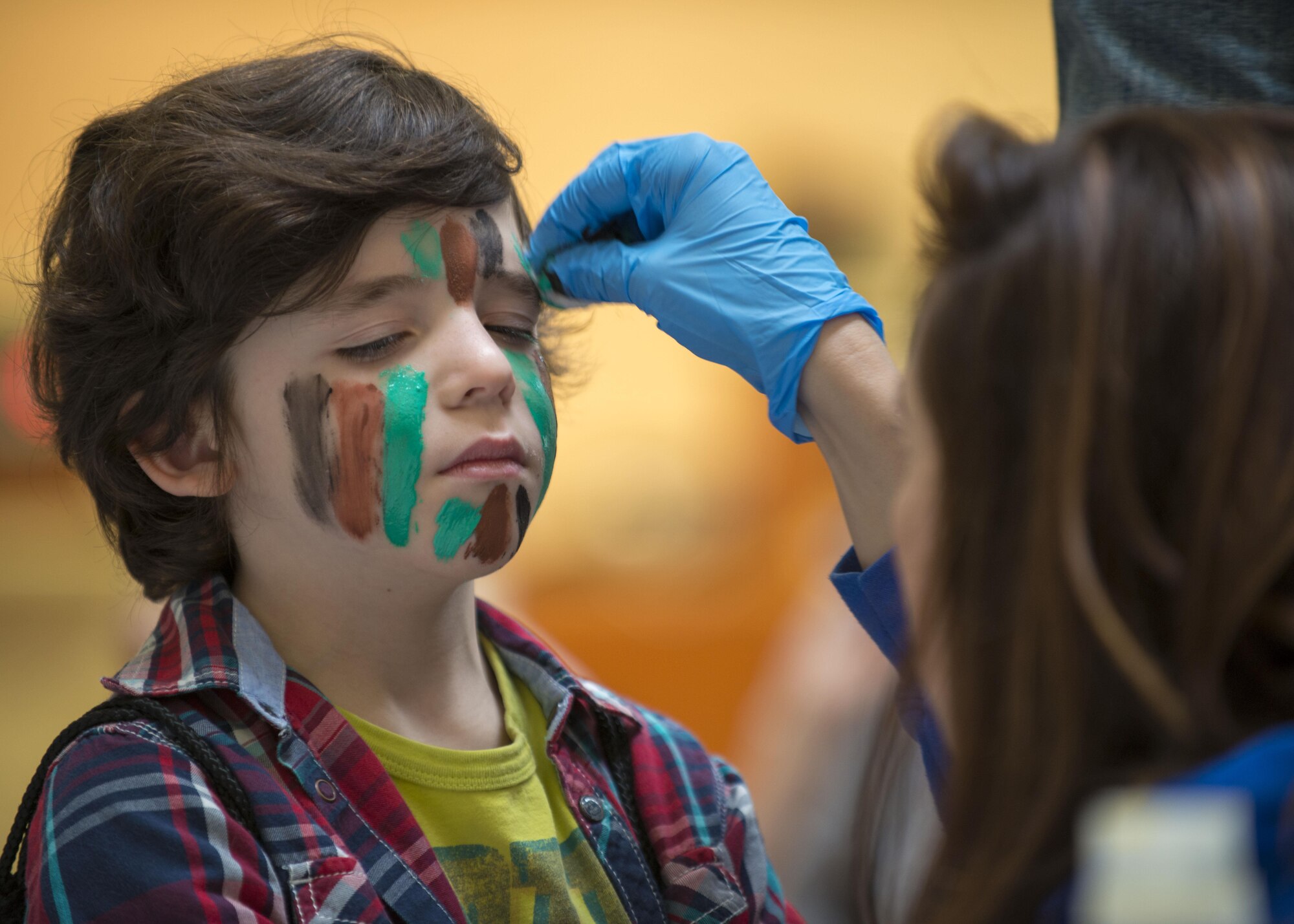 Teagan Dockens, Aviano Elementary School student, has his face painted during a Little Wyvern Warriors deployment line May 5, 2016, at Aviano Air Base, Italy. Children began their mock deployment line by getting their faces painted as the kids ‘prepared for battle’. (U.S. Air Force photo by Airman 1st Class Cory W. Bush/Released)