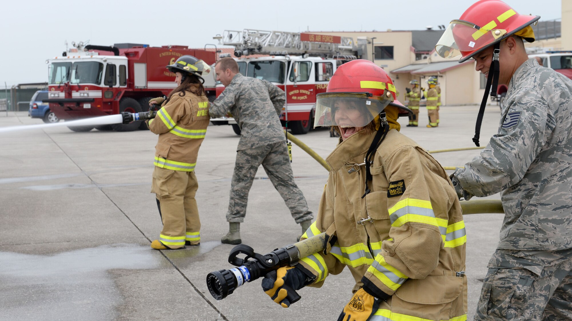Airmen from the 31st Civil Engineer Squadron fire management flight help spouses use water hoses during the first wing-led Spouses Appreciation Day tour, May 10, 2016, at Aviano Air Base, Italy. Spouses participated in hands-on activities to better understand the 31st Fighter Wing’s mission. (U.S. Air Force photo by Airman 1st Class Cary Smith/Released)
