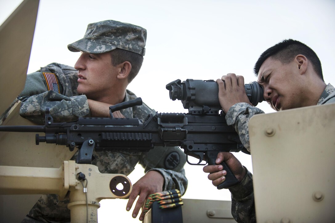 Army Pfc. Ryan Joe, right, looks through a night vision scope on an M240B machine gun with the help of Army Spc. Bradley Schopf before they participate in a night-fire qualification at Fort Hunter Liggett, Calif., May 3, 2016. Joe and Schopf are military police officers assigned to the 341st Military Police Company. Army photo by Master Sgt. Michel Sauret