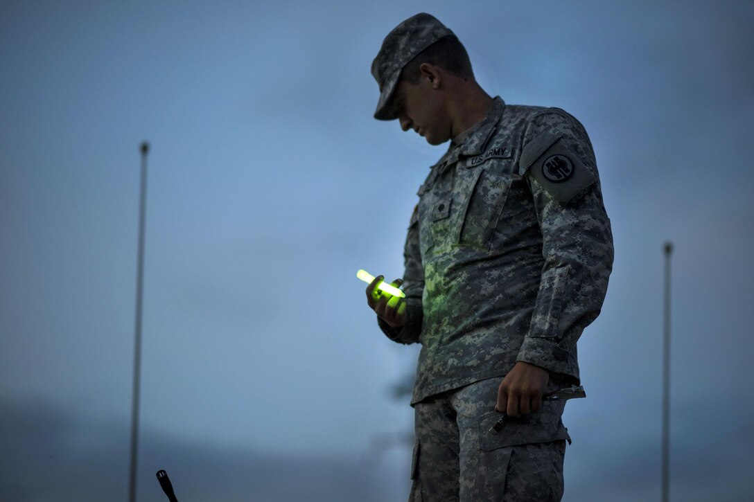 Army Spc. Bradley Schopf holds a glow stick before participating in a night-fire qualification at Fort Hunter Liggett, Calif., May 3, 2016. Schopf is a military police officer assigned to the 341st Military Police Company. Army photo by Master Sgt. Michel Sauret