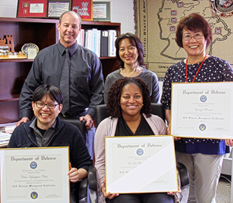 It’s official! All eligible employees of the Resource Management Office and the Internal Review Office have earned DoD Financial Management certifications. Employees of the Far East District Resource Management Office showcase their certifications:  
Seated: Chris Choi, LaShun Medlock. Standing: Robert Derrane, Haekyung Cho and Young Phoenix (Young Jin and Sgt. 1st Class Diomedes Tuazon were unavailable). 


  
The certification program, authorized under the 2012 National Defense Authorization Act, provides a DoD-wide framework to guide professional development and adapt to future requirements. The program has three different levels, each with baseline requirements that incorporate experience, education, training and leadership development. The program began in July 2014, and required eligible employees in the 500 series (Financial Management) to complete the requirements as a condition of employment by 2016.
The program also identifies training gaps and provides leaders the ability to prioritize future training and allocate resources. Much of the training is online but the program allows employees to use past college courses and professional developmental assignments to fulfill the requirements. Employees are required to take 80 continuing professional education credits over the next two years to maintain their certification. It is expected that the program will soon be expanded to include employees in the 0343 series (Management & Program Analysts).
