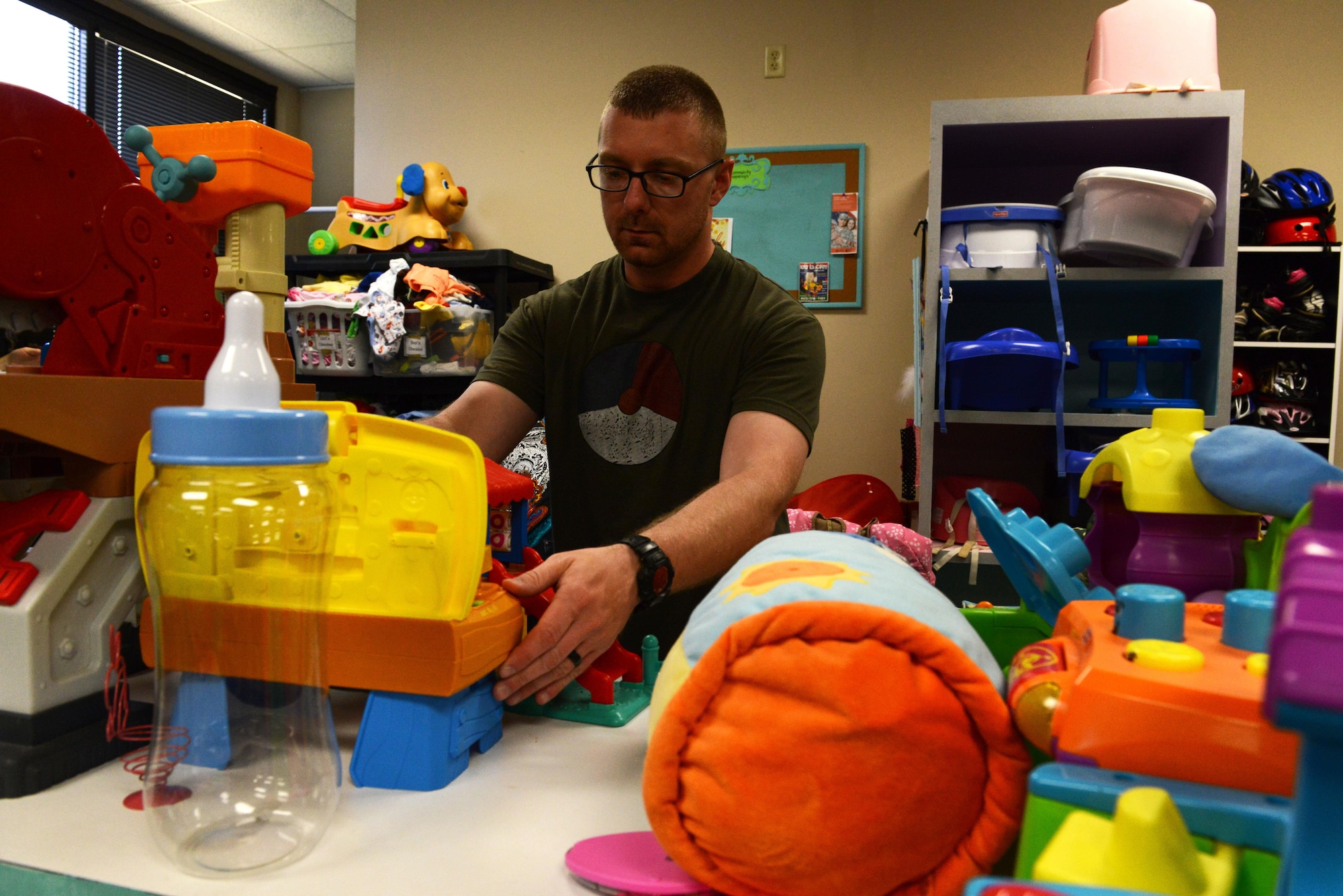 U.S. Air Force Tech. Sgt. Michael Kraft, 20th Aircraft Maintenance Squadron avionics systems craftsman, organizes children’s toys at the Attic at Shaw Air Force Base, S.C., April 21, 2016. Often volunteering more than six hours a week, Shaw Attic volunteers help sort donated items, keep the store clean and run the front desk. (U.S. Air Force photo by Airman 1st Class Destinee Dougherty)