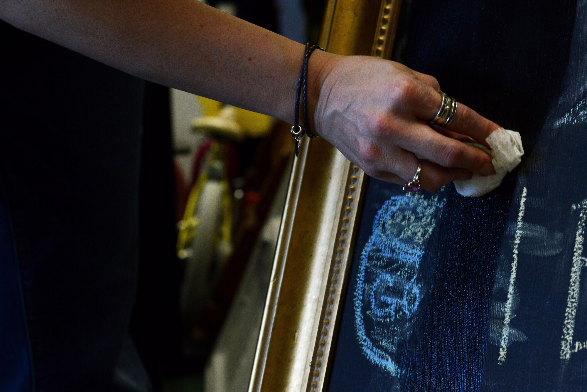 Madeline Kraft, Shaw Attic volunteer, cleans a blackboard at the Attic on Shaw Air Force Base, S.C., April 19, 2016. Attic volunteers use the blackboard to advertise deals on items, such as 10-for-1 books. The Attic offers items ranging from military uniforms to children’s toys, giving back to the community more than 4,000 products a month. (U.S. Air Force photo by Airman 1st Class Destinee Dougherty)