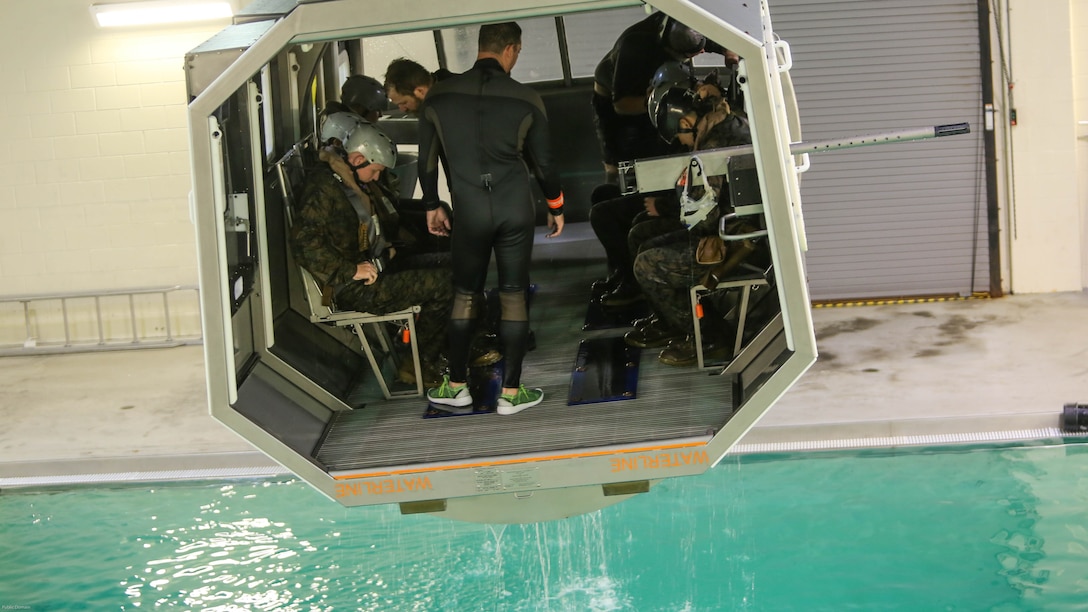 Marines with Marine Medium Tiltrotor Squadron 264 prepare to plunge into the water during survival training at Marine Corps Base Camp Lejeune, Apr. 28, 2016. The Marines used a simulated helicopter body while training for different underwater escape scenarios as qualification to be attached to a Marine Expeditionary Unit. 