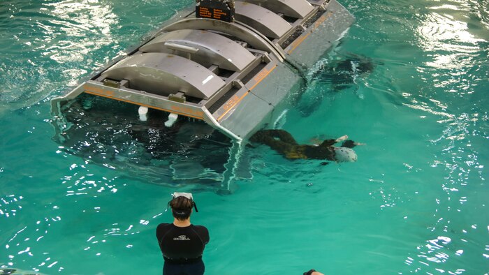 Marines with Marine Medium Tiltrotor Squadron 264 escape the cage after it sinks and flips upside down during water survival training at Marine Corps Base Camp Lejeune, Apr. 28, 2016. The Marines used a simulated helicopter body while training for different underwater escape scenarios as qualification to be attached to a Marine Expeditionary Unit.  