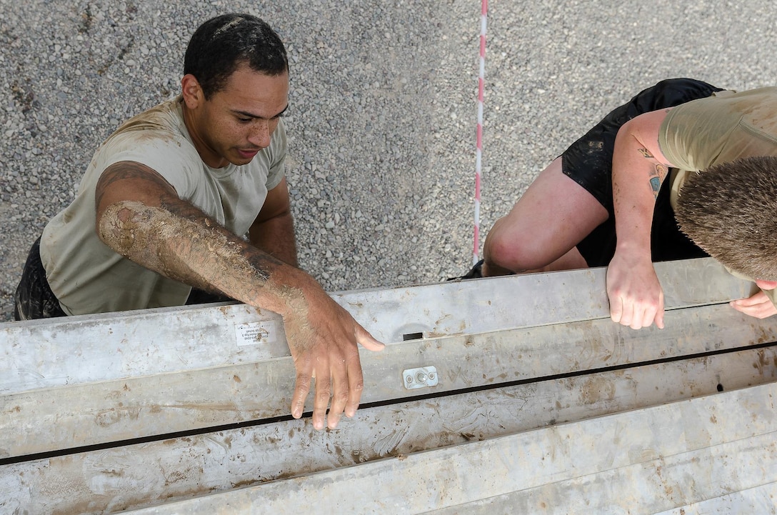Spc. Jordan Konvalin, a Soldier assigned to Operations Company, Headquarters and Headquarters Battalion, 101st Airborne Division (Air Assault), climbs up an obstacle during the Kurdish Training Coordination Center Survival Fun Run held near Erbil, Iraq, May 6, 2016. The Morale, Welfare and Recreation event consisted of the choice between a 5-, 10- or 15-kilometer route with obstacles spread throughout and allowed Soldiers to have fun and build camaraderie with their peers. (U.S. Army Photo by Staff Sgt. Peter J. Berardi)