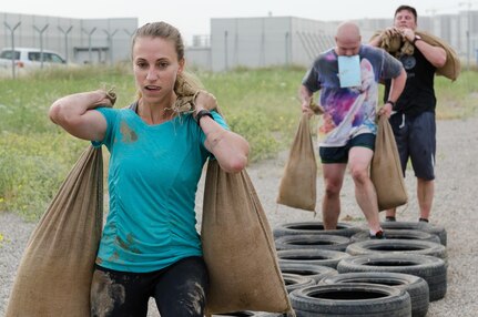 Capt. Victoria Salibi, a member of the Staff Judge Advocate section, Operations Company, Headquarters and Headquarters Battalion, 101st Airborne Division (Air Assault), carries sandbags after running through a tire obstacle during the Kurdish Training Coordination Center Survival Fun Run held near Erbil, Iraq, May 6, 2016. The Morale, Welfare and Recreation event consisted of the choice between a 5-, 10- or 15-kilometer route with obstacles spread throughout and allowed Soldiers to have fun and build camaraderie with their peers. (U.S. Army Photo by Staff Sgt. Peter J. Berardi)