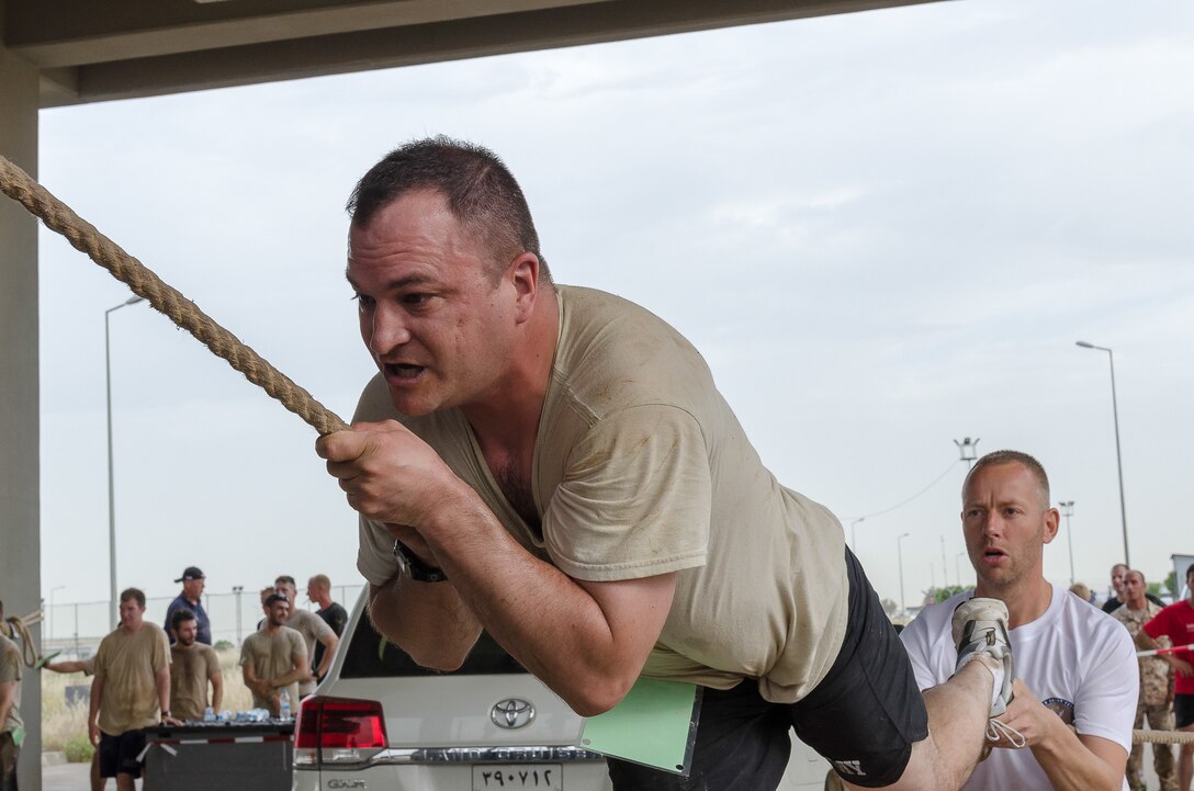 Staff Sgt. Gregory Rakovszky, a command net radio specialist with Operations Company, Headquarters and Headquarters Battalion, 101st Airborne Division (Air Assault), climbs a rope obstacle with a little help from a coalition member during the Kurdish Training Coordination Center Survival Fun Run held near Erbil, Iraq, May 6, 2016. The Morale, Welfare and Recreation event consisted of the choice between a 5-, 10- or 15-kilometer route with obstacles spread throughout and allowed Soldiers to have fun and build camaraderie with their peers. (U.S. Army Photo by Staff Sgt. Peter J. Berardi)