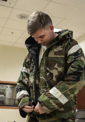 Staff Sgt. Joshua Anderson, 51st Aircraft Maintenance Squadron maintainer, prepares his chemical protection suit prior to the start of his shift, at Osan Air Base, Republic of Korea, May 10, 2016. The 51st AMXS is responsible for the maintenance and repair of Osan’s F-16 Fighting Falcons and A-10 Thunderbolt IIs. (U.S. Air Force photo by Tech. Sgt. Travis Edwards/Released)