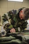 Staff Sgt. Joshua Anderson, 51st Aircraft Maintenance Squadron maintainer, prepares his chemical protection suit prior to the start of his shift, at Osan Air Base, Republic of Korea, May 10, 2016. The 51st AMXS is responsible for the maintenance and repair of Osan’s F-16 Fighting Falcons and A-10 Thunderbolt IIs. (U.S. Air Force photo by Tech. Sgt. Travis Edwards/Released)