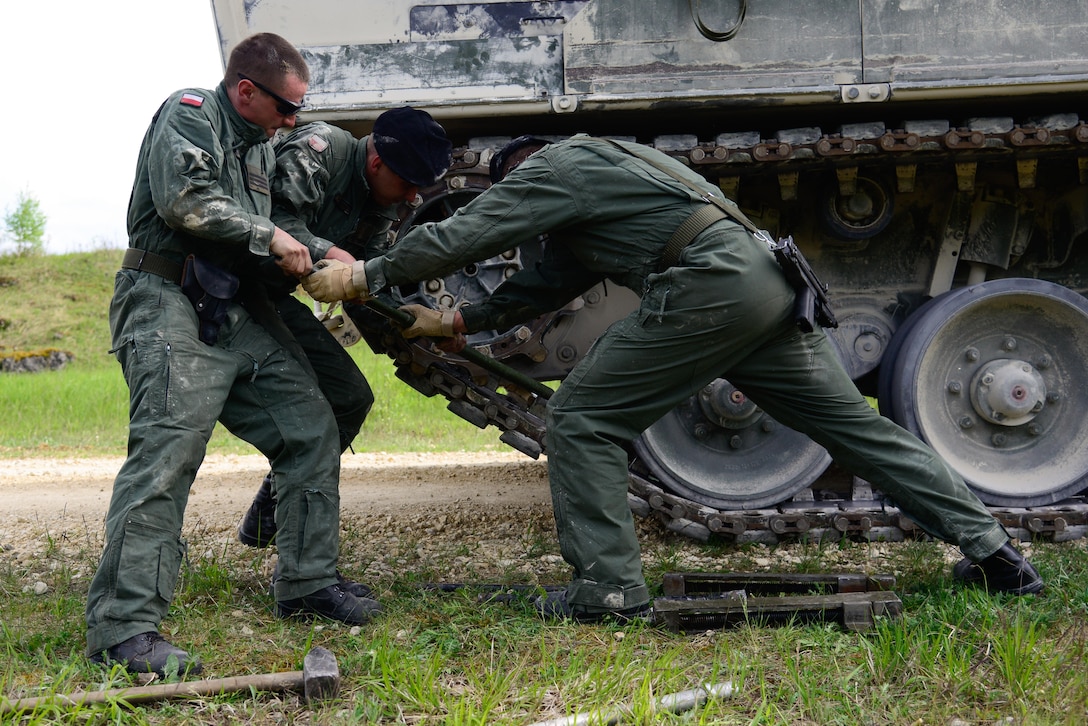 Polish soldiers conduct track maintenance on a Polish Leopard tank during the Strong Europe Tank Challenge in Grafenwoehr, Germany, May 10, 2016. Army photo by Pfc. Emily Houdershieldt