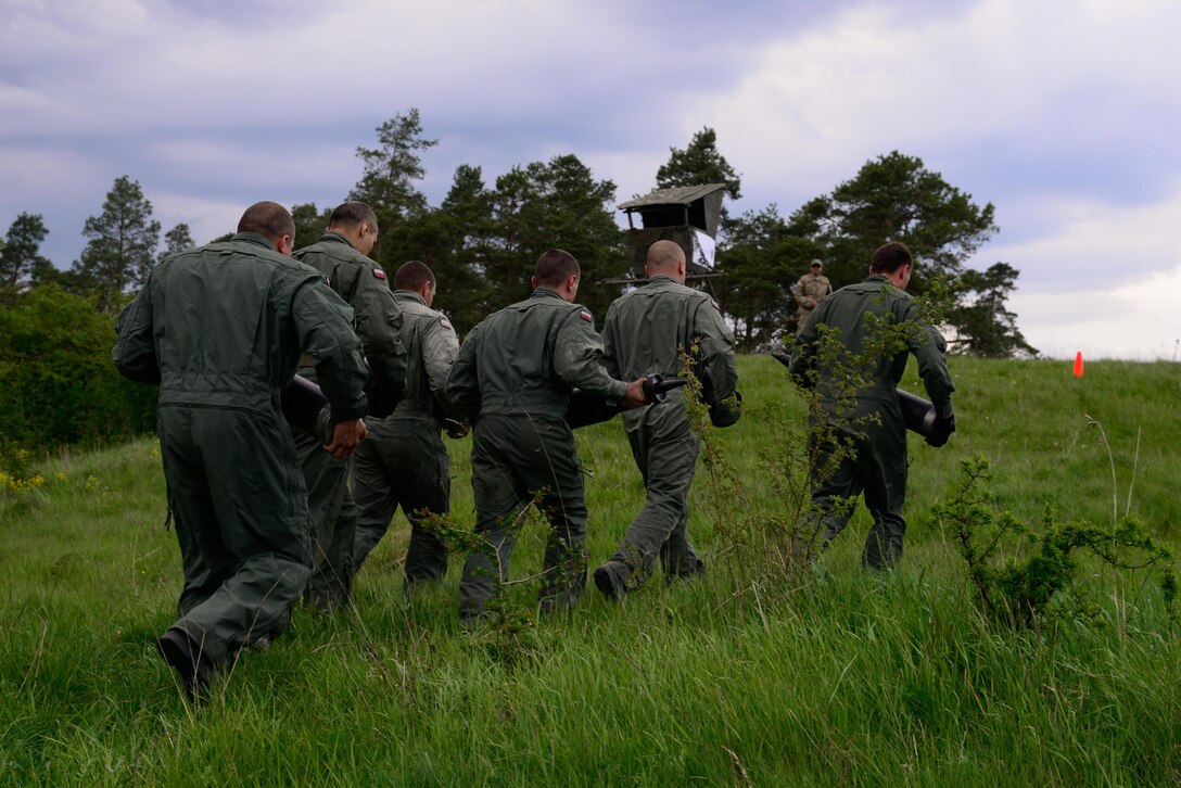 Polish soldiers carry an assortment of tank rounds as a U.S. soldier looks on during the Strong Europe Tank Challenge in Grafenwoehr, Germany, May 10, 2016. Army photo by Pfc. Emily Houdershieldt