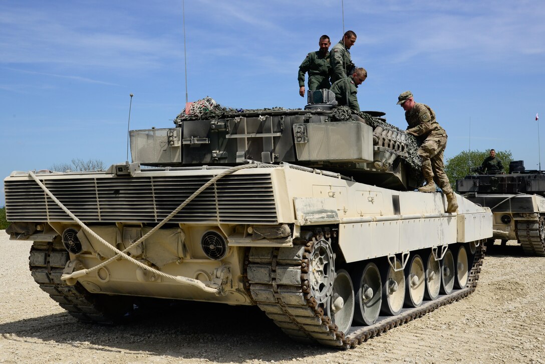 Polish soldiers show their Leopard tank to a U.S. soldier during the Strong Europe Tank Challenge in Grafenwoehr, Germany, May 10, 2016. Army photo by Pfc. Emily Houdershieldt