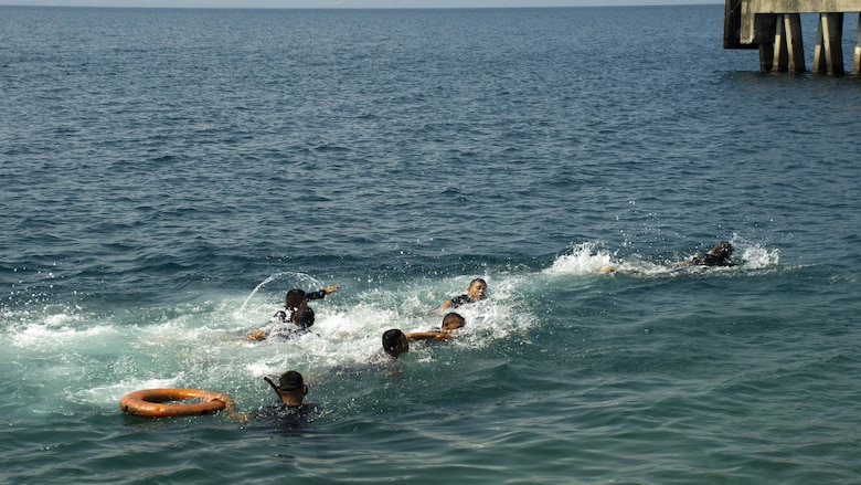 Enlisted trainees with the Honduran Navy participate in a swimming test April 4, 2016, on the northern coast of Honduras, to determine their skill level in the water. The swimming test is used to help determine the amount of additional training the members require during the XX-week basic infantry course. 